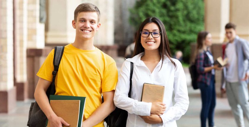 Happy diverse students having break in university campus, smiling to camera